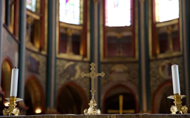 Beautiful church altar with a gold cross and candles, showcasing spirituality and religious serenity.