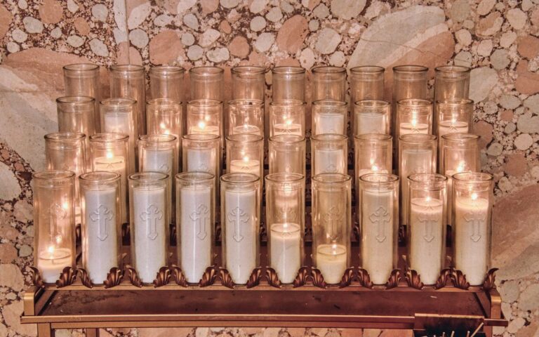 A serene display of candles in a religious setting, symbolizing offering and prayer.