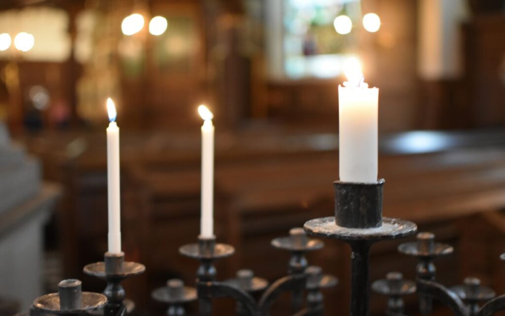 Serene scene of candles burning inside a church, creating a peaceful ambiance.