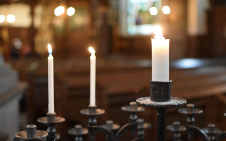 Serene scene of candles burning inside a church, creating a peaceful ambiance.