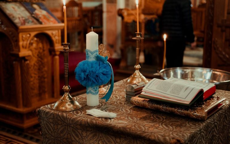 A beautifully decorated altar in a church featuring candles, an open book, and traditional wooden carvings.