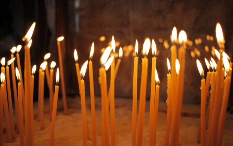 Warm and peaceful image of lit candles inside a church, symbolizing faith and reflection.