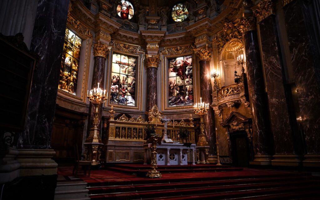 A stunning view of an ornately decorated church interior with stained glass windows and gold accents.