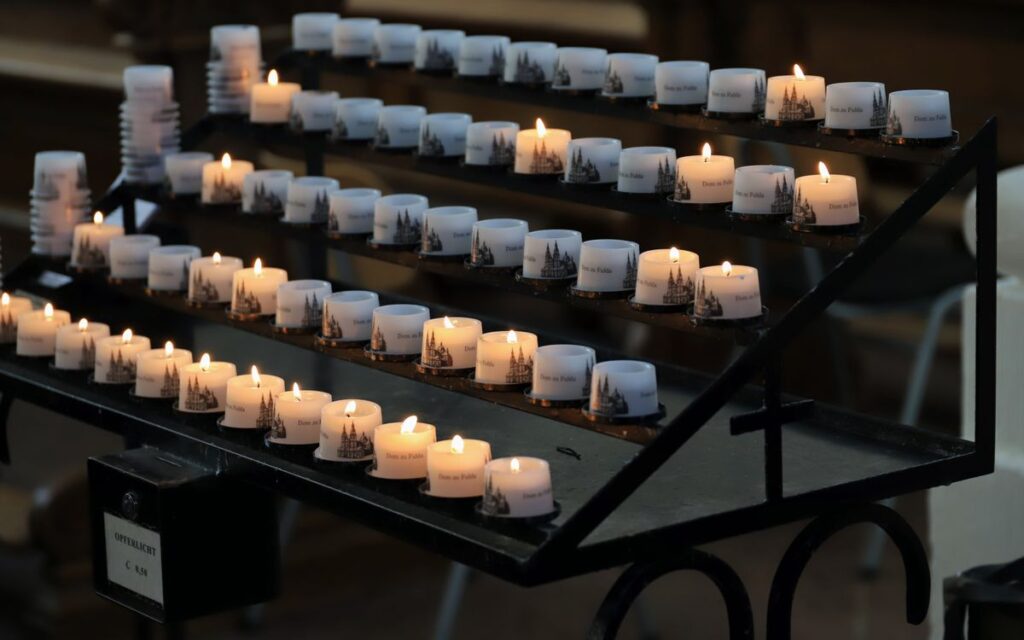 Votive candles lit in Fulda Cathedral, creating a serene religious atmosphere.