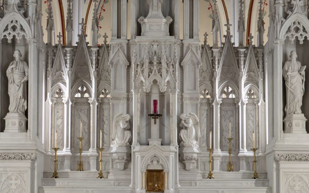A detailed view of a Gothic-style church altar with sculptures, highlighting intricate architectural elements.