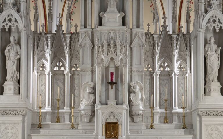 A detailed view of a Gothic-style church altar with sculptures, highlighting intricate architectural elements.