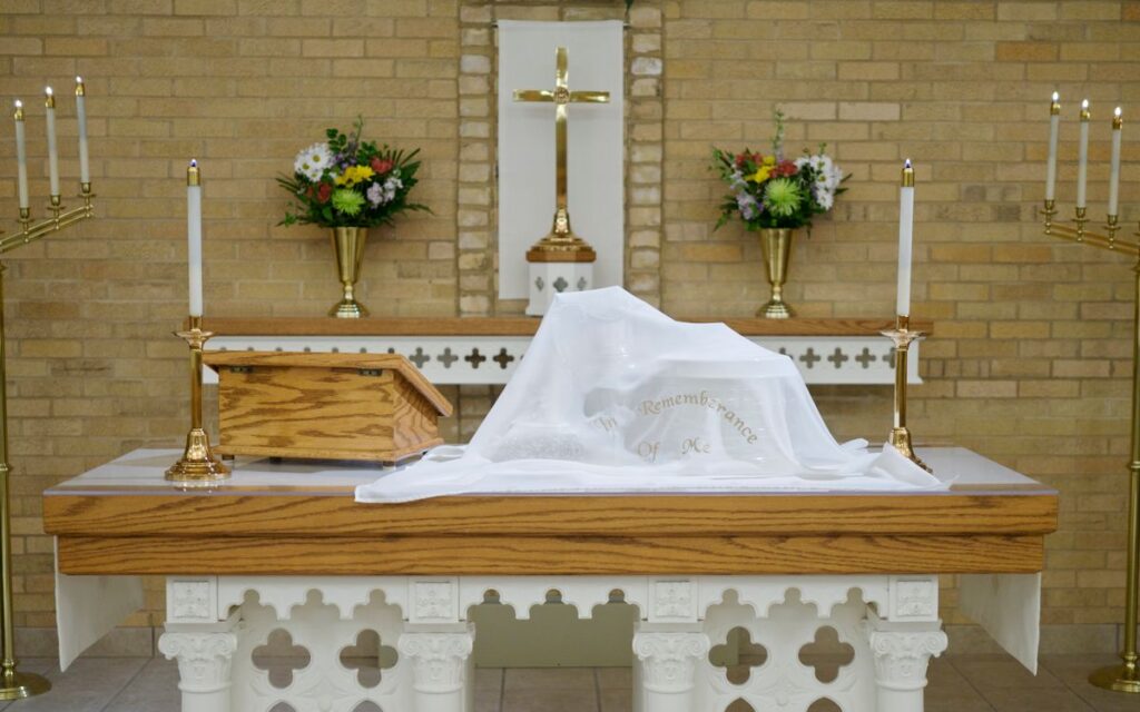 A church altar with candles, cross, and flowers, perfect for religious themes.