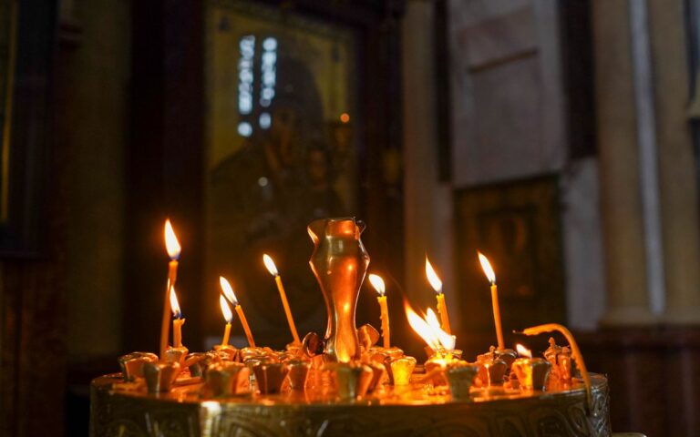 Lit candles in a religious setting create a warm and serene atmosphere.