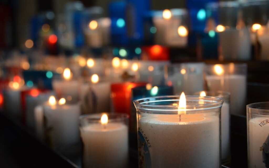 A collection of lit candles in a church, creating a serene and warm atmosphere.